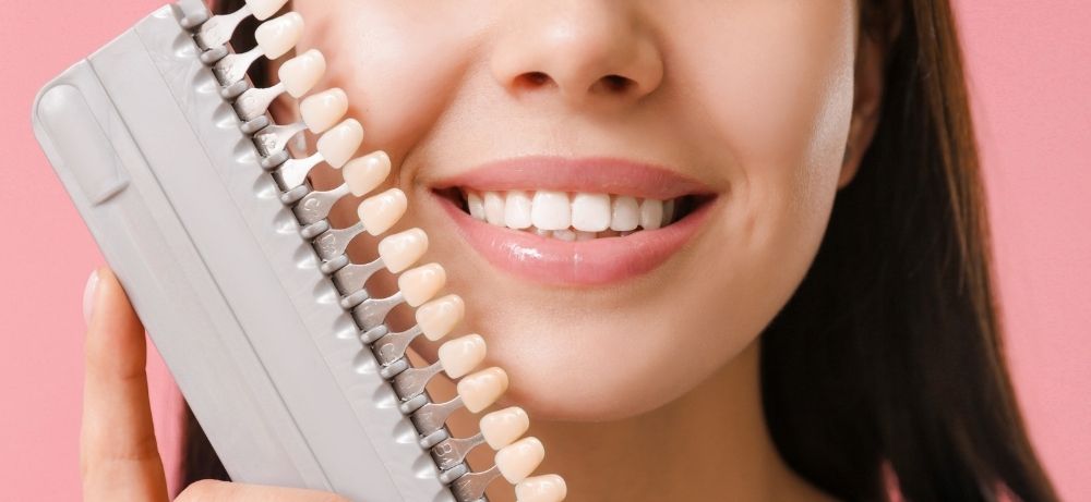 kvinnlig patient jämför skalfasader Tandläkare går igenom processen för estetisk tandvård för patient